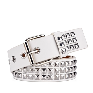 Detailopname van witte punkleren riem met drie rijen zilveren vierkante piramidevormige studs