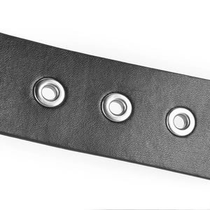 Vue détaillée d'une ceinture punk en cuir noir montrant des œillets métalliques argentés