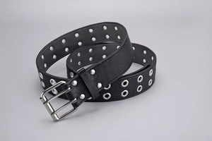 Detail of punk style black double-grommet belt with vintage silver double-pin buckle