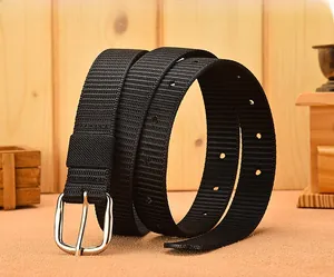 Detail of black woven canvas belt with silver metal pin buckle on wooden background