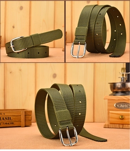Detail of army green canvas belt with silver pin buckle and sturdy woven texture