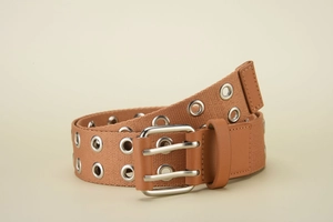 Detail of khaki canvas belt featuring double metal grommets and silver double prong buckle