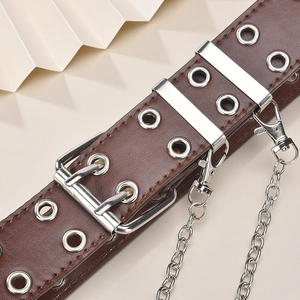 Detailaufnahme von braunem Punk-Ledergürtel mit silbernen Ösen und abnehmbarer Kette