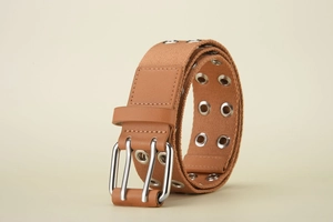 Detail view of khaki canvas belt featuring double prong silver buckle and twin metal eyelets