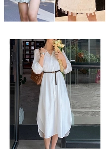 Detail view of a slim brown leather belt with a metal buckle on a white midi shirt dress