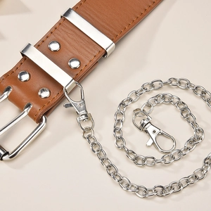 Detail eines braunen Ledergürtels mit silbernen Metallketten und Nieten für Stil