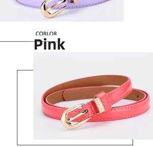 Détail d'une fine ceinture en cuir rose pour femme avec boucle dorée à motifs vintage