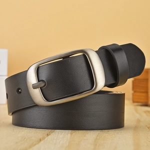Classic black faux leather belt with brushed metal pin buckle on a wooden background