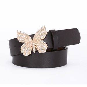 Detailed view of the luxury gold butterfly buckle with sparkling rhinestones on black leather belt