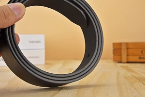 Detail showing the fine edge stitching and smooth leather texture of the black fashion belt