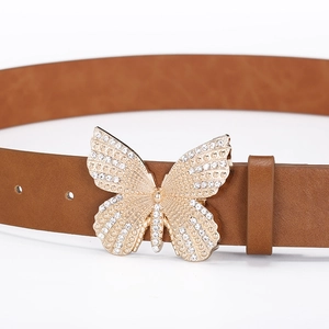 Close-up of golden butterfly buckle with white rhinestones on brown leather belt
