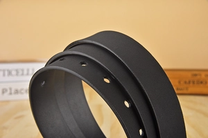 Macro detail of black matte leather belt with clean edges and round adjustment holes