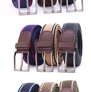 Close-up of elastic woven belt texture with metal pin buckle and embossed leather tip