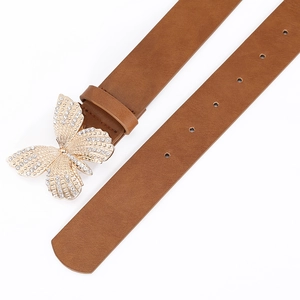 Close-up of caramel brown leather belt with butterfly buckle and sparkling crystals