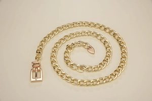 Detailed macro view of the polished golden Cuban link chain belt with needle buckle closure