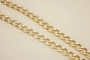 Detail of high-polished 18K light gold thick metal chain strap with mirror finish effect