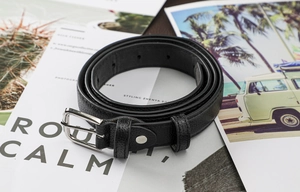 Détail de la ceinture noire en cuir pour femme avec texture litchi et boucle ardillon argent