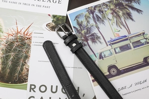 Détail d'une ceinture noire en cuir grainé avec boucle ardillon carrée argentée