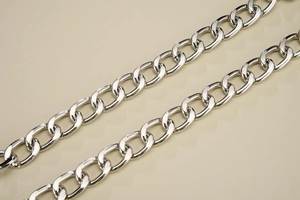 Detailed macro view of polished silver metal curb chain with high gloss finish