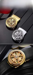 Detail of rotating round buckle with crystal cross design on black leather belt