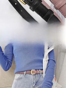 Gros plan sur une ceinture fine en cuir pour femme avec boucle fer à cheval dorée