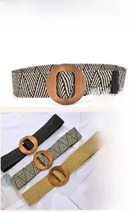 Detail of bohemian elastic woven belts with round wooden buckles in multiple colors