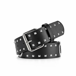 Detail van zwarte lederen riem met drie rijen zilveren piramide-studs en gespsluiting