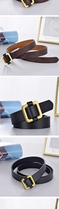Detail view of brown and black leather belts with matte gold square buckle on wood surface