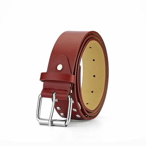 Detail van een wijnrode lederen riem met zilveren vierkante studs en een metalen gesp