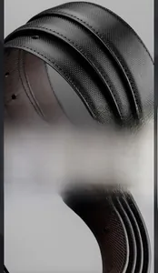 Macro detail of men's black leather belt showing refined edge paint and cross-grain texture