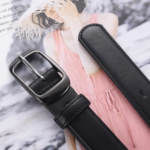 Ceinture femme en cuir noir classique avec boucle en métal gris foncé sur des magazines
