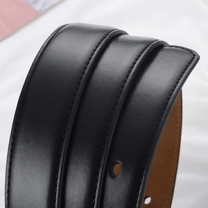 Gros plan d'une ceinture en cuir noir montrant la texture fine et les coutures