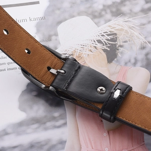 Ceinture en cuir marron classique avec boucle ardillon noire sur fond de magazine de mode