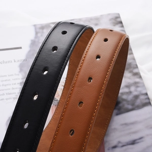 Vue détaillée des ceintures en cuir noir et marron avec texture grainée et coutures
