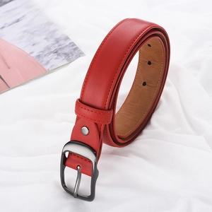Vue détaillée d'une ceinture en cuir rouge vif avec boucle en métal sur tissu blanc