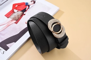 Vue détaillée de la ceinture en cuir noir avec boucles dorées ornées de strass brillants