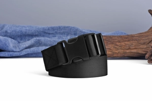 Close-up of black nylon belt with matte plastic buckle on creative rustic background