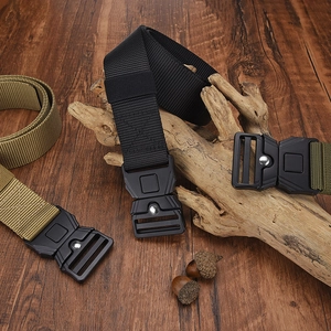 Close-up of tactical nylon web belt showing durable metal quick-release buckle on wood