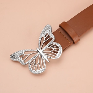 Détail d'une ceinture en cuir marron avec boucle papillon argentée ornée de strass brillants