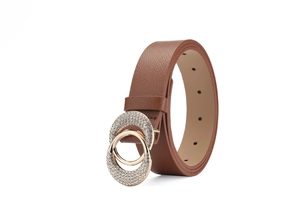 Détail d'une ceinture en cuir marron avec boucle de luxe à double anneau en strass