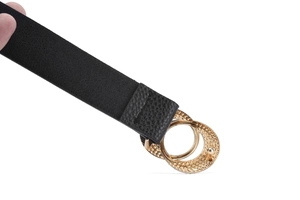 Gros plan sur une ceinture noire en cuir grainé avec une boucle dorée à double anneau
