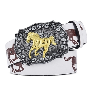 Close-up of Western cowboy belt buckle with silver floral carving and golden horse relief