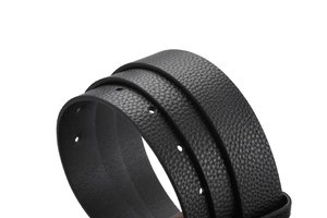 Gros plan sur la texture grainée du cuir noir et les trous de réglage de la ceinture