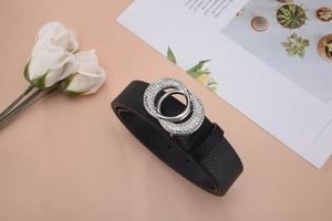 Detailansicht eines schmalen schwarzen Ledergürtels mit zwei Ringen und glitzernden Strasssteinen
