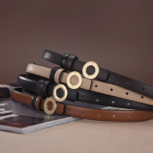 Detail view of slim leather belts in coffee, beige, black, and tan with gold round buckles