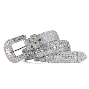 Dettaglio macro della cintura strass Y2K con cinturino glitter argento e fibbia con rilievi