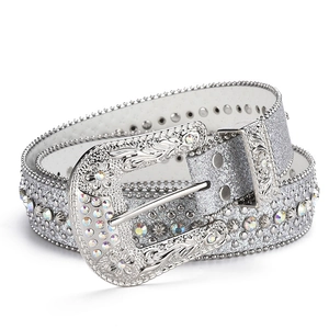 Dettaglio ravvicinato della cintura strass Y2K con cinturino argento e fibbia floreale