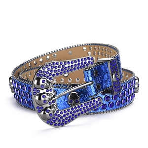 Detail of blue rhinestone belt featuring silver skull buckle and glitter leather strap