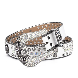 Detail of white crocodile pattern belt with skull buckle and sparkling rhinestones