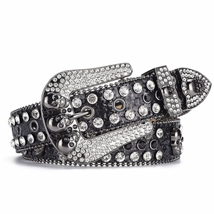 Detailed macro of punk rock leather belt with rhinestone skull buckle and silver studs